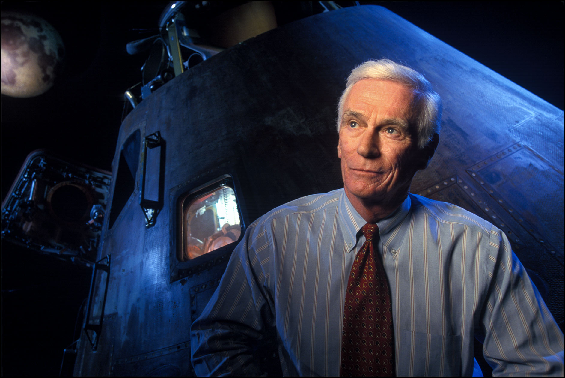 Eugene Cernan, former Apollo astronaut who walked on the moon, in front of an Apollo space capsule display.