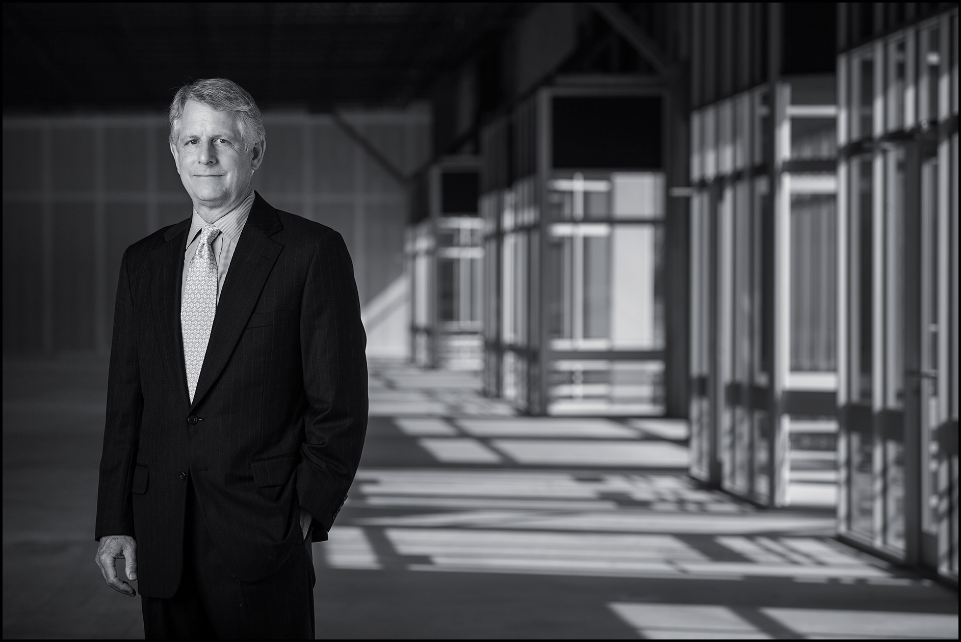 A real estate CEO stands in a vacant commercial warehouse space.